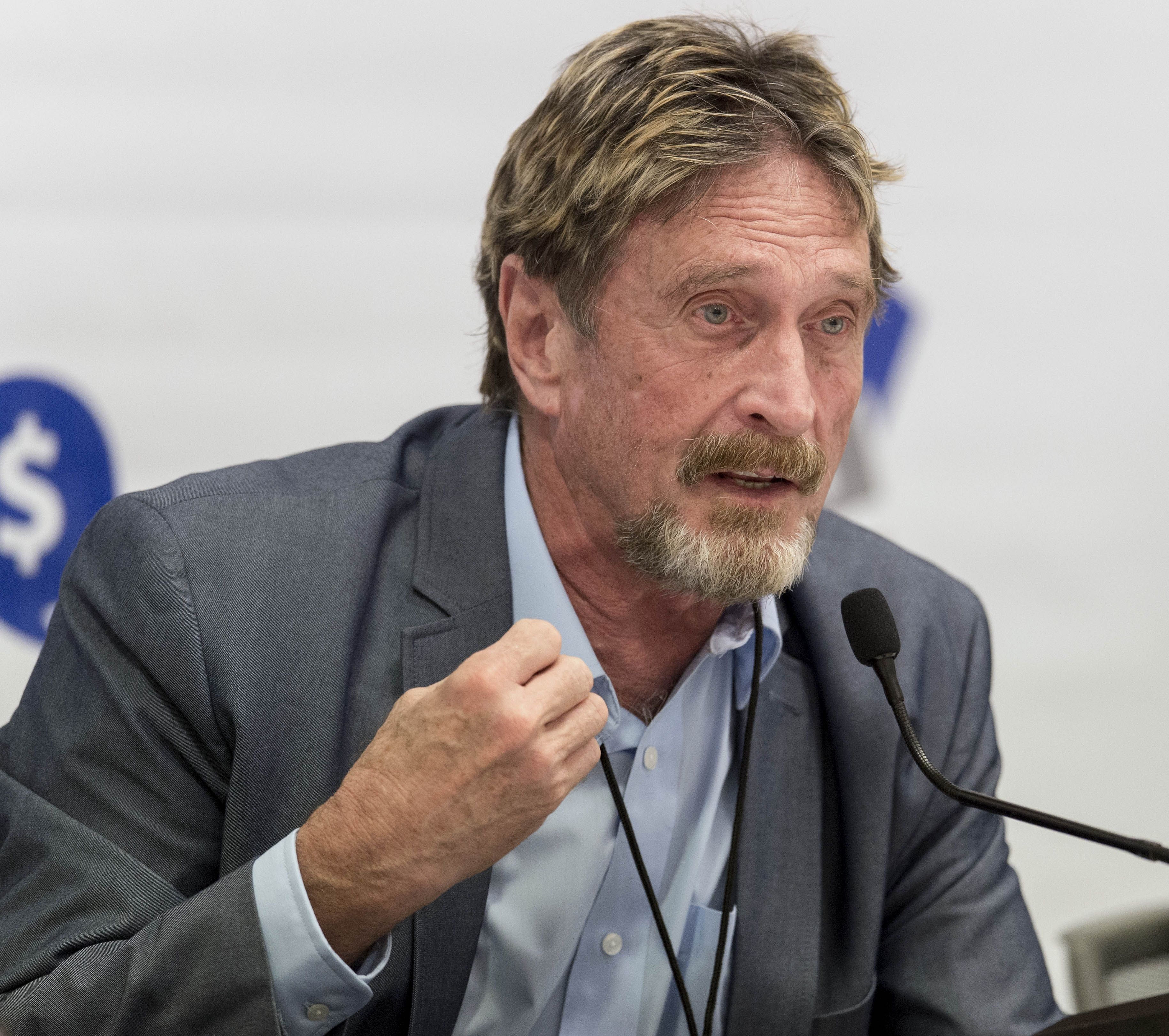 Why has John McAfee's body been in a Barcelona morgue for seven months?