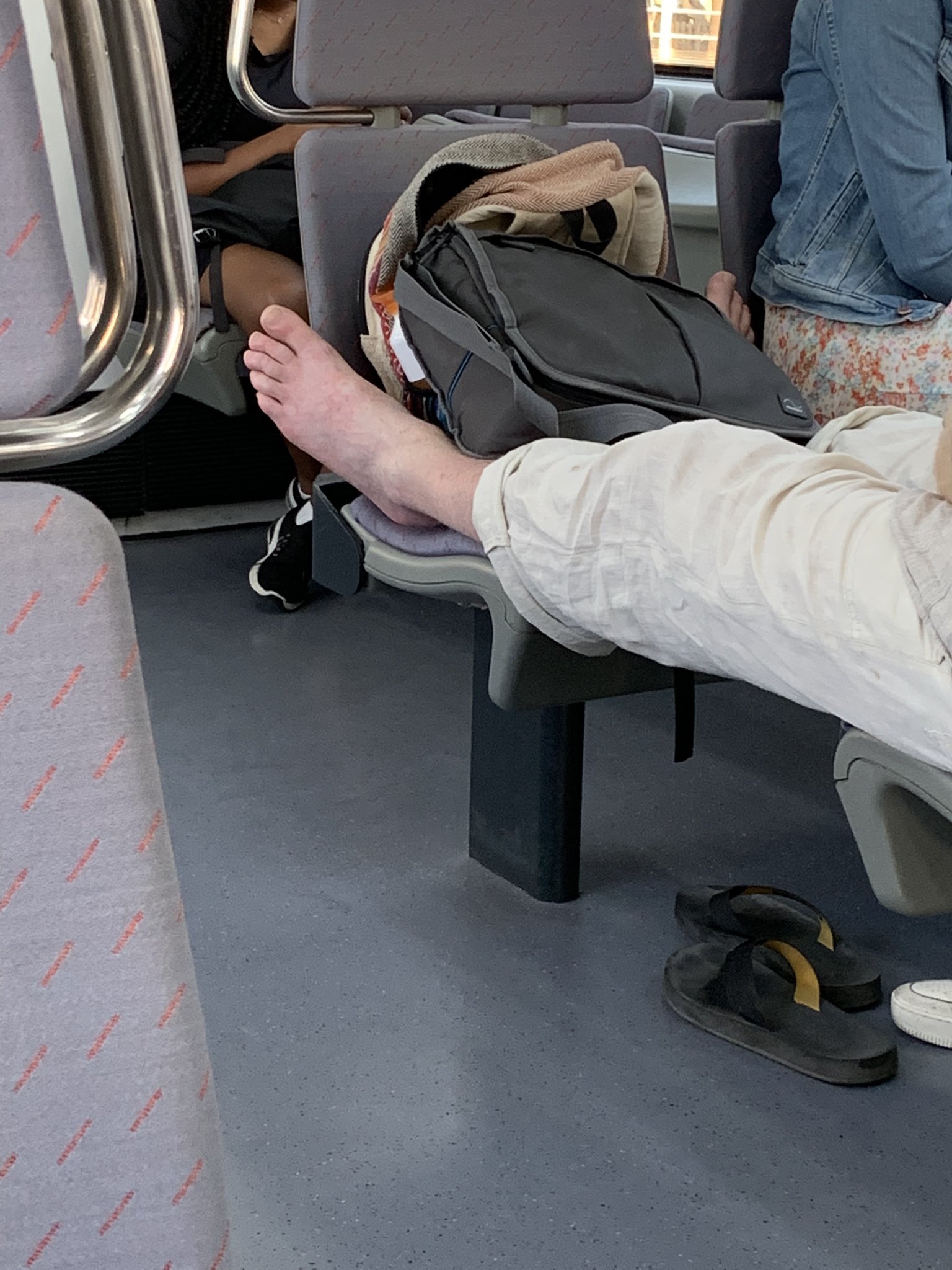 Tipo descalzo en el asiento del tren, una mujer se enfrenta y Toni Clapés aplaude