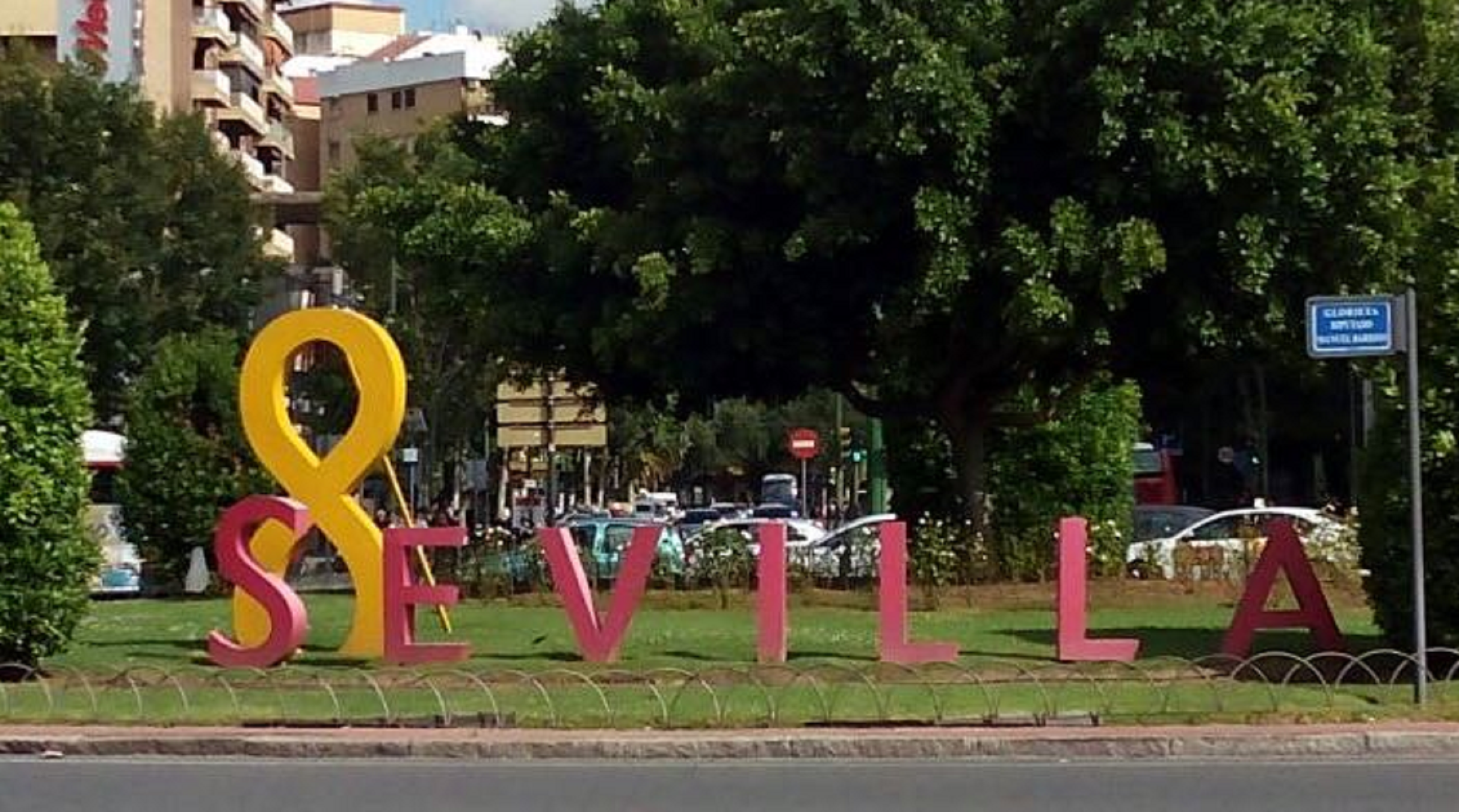 Los turistas en Sevilla, contra la rotonda con un enorme lazo amarillo