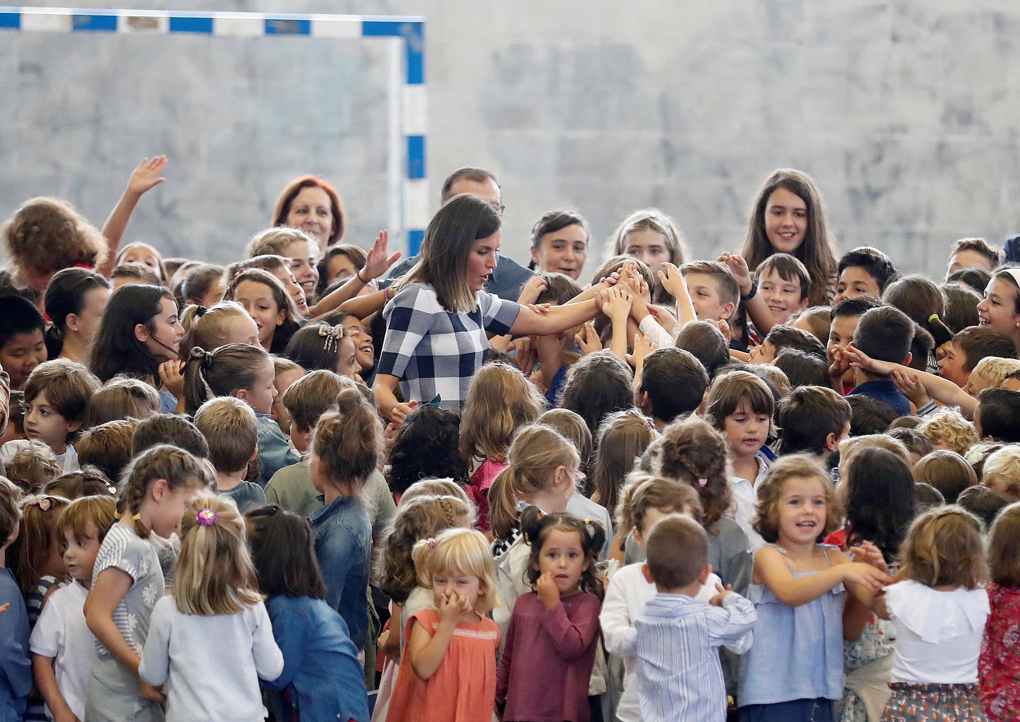 La reina Letizia, adorada por un montón de niños durante la inauguración del curso