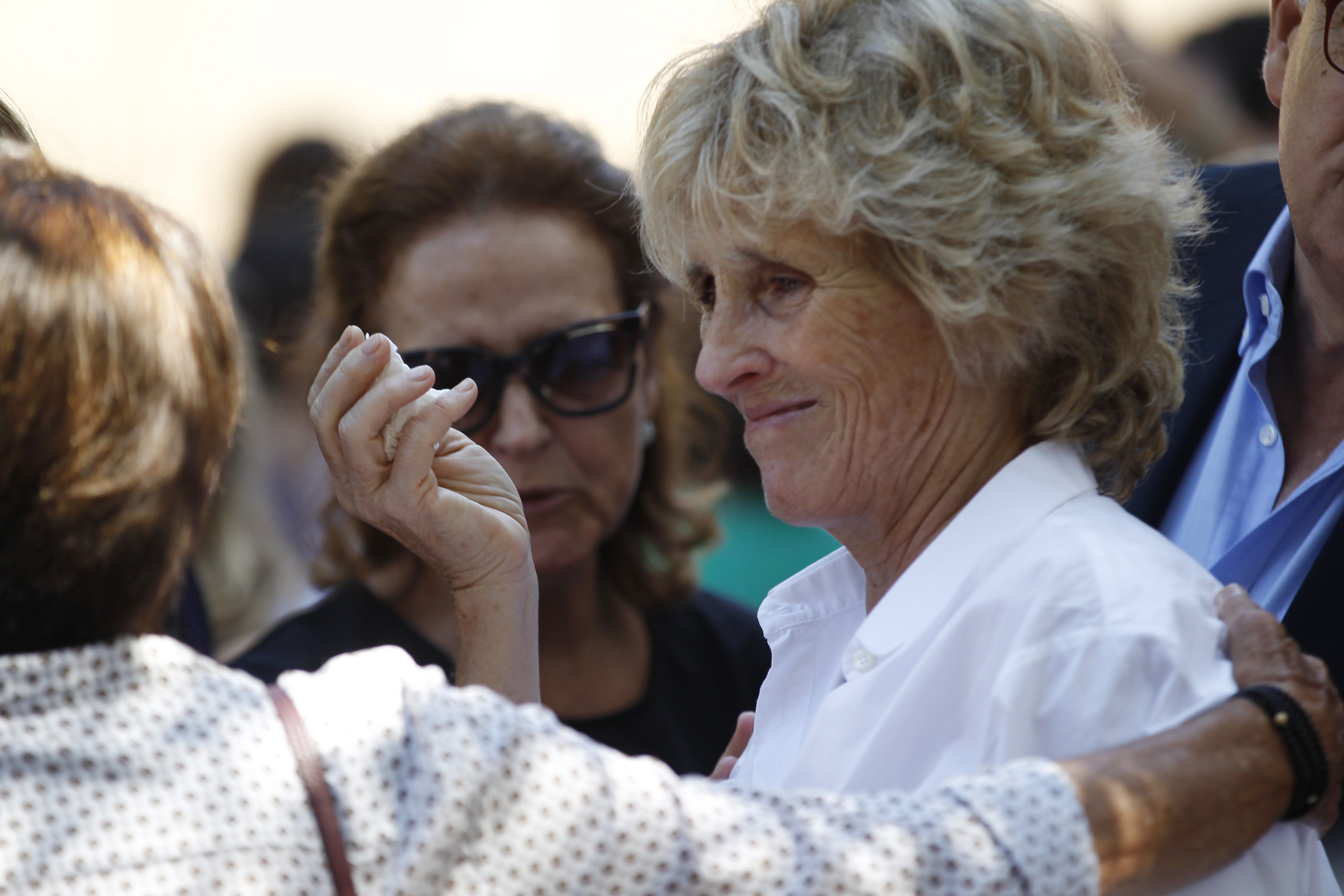 Mercedes Milá, de blanco, llora en el funeral de su madre, muerta a los 93 años