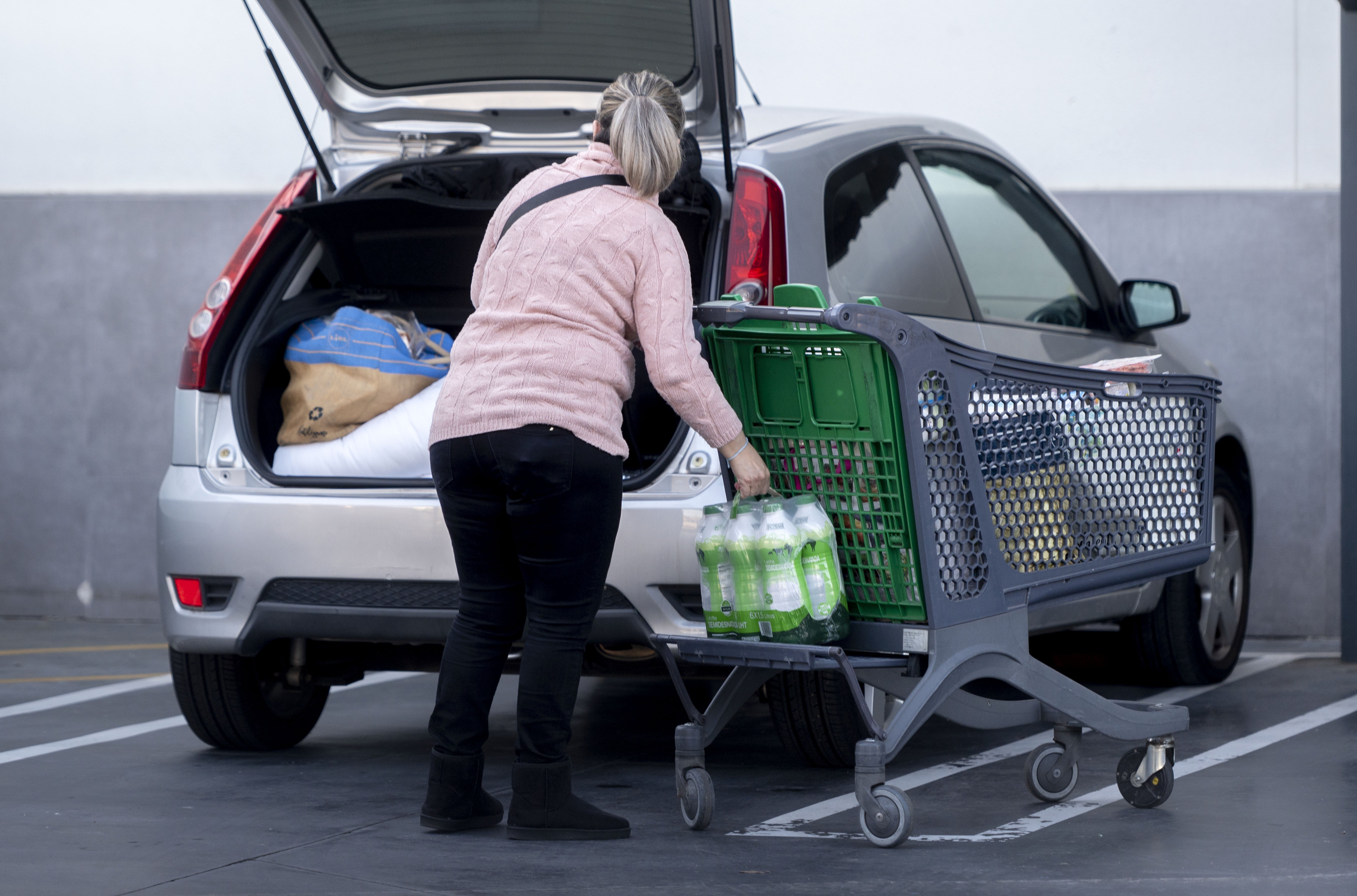 Una mujer mete la compra en el coches. Europas Press