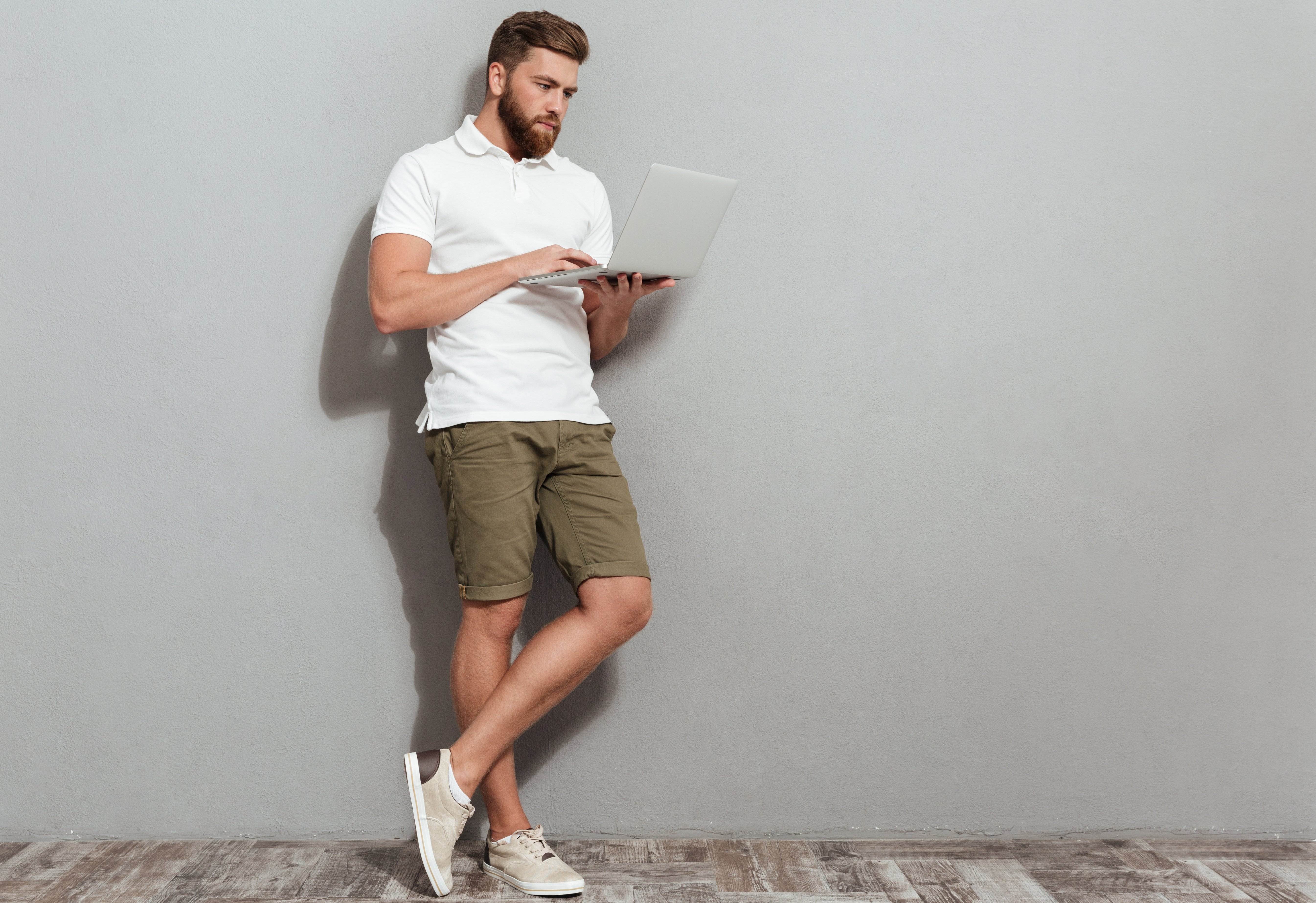 full length image bearded man using laptop computer