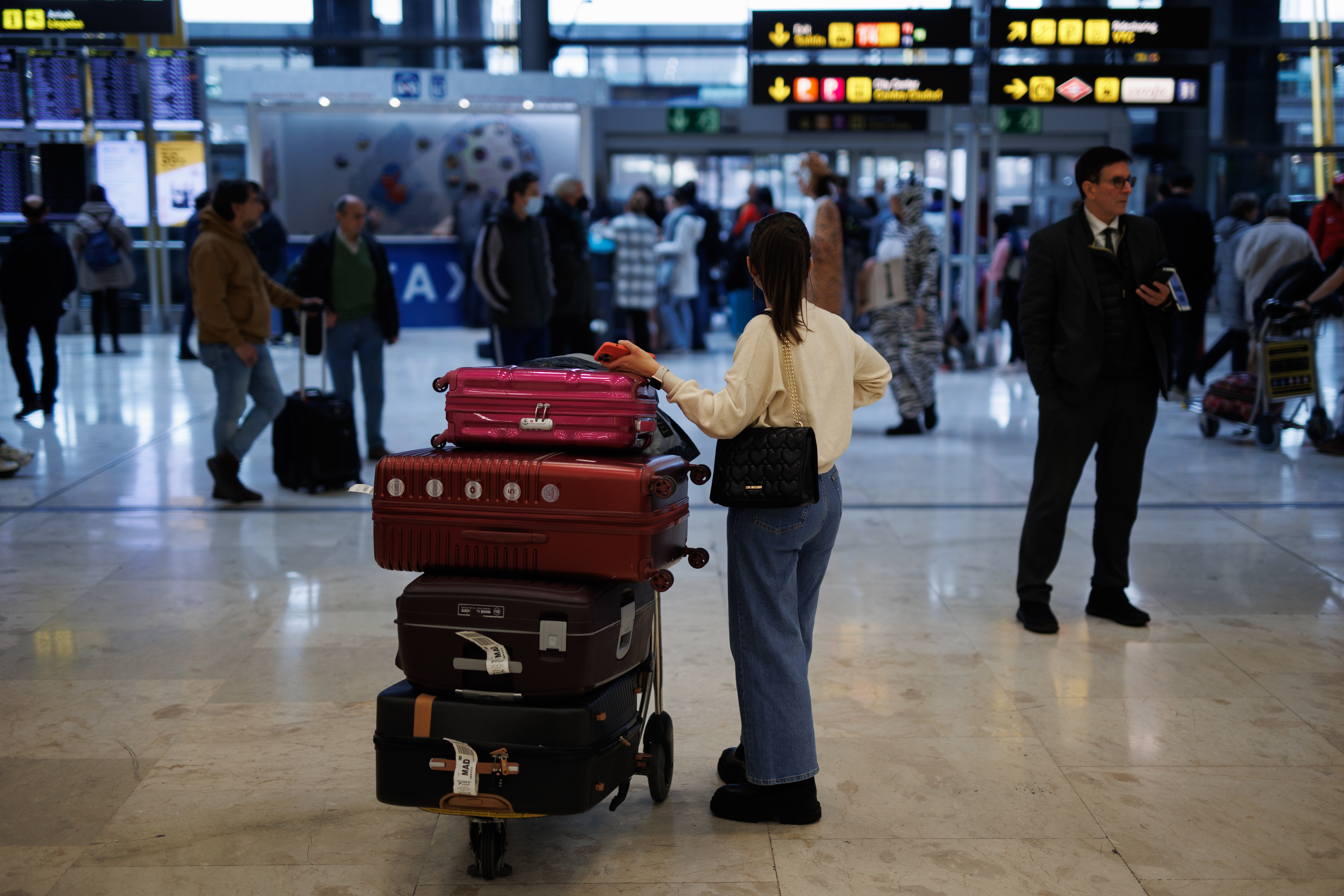 Una pasajera espera facturar sus maletas en el aeropuerto