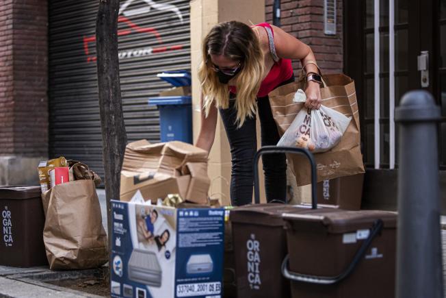 Veïna tirant les escombraries orgàniques a Sant Andreu