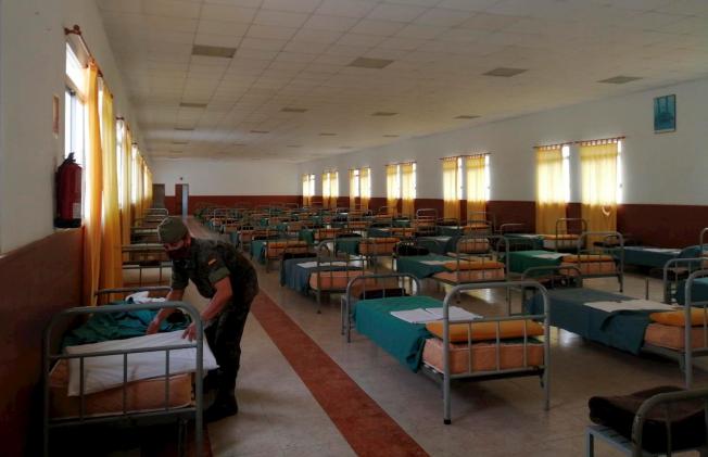 A soldier prepares beds for evacuees