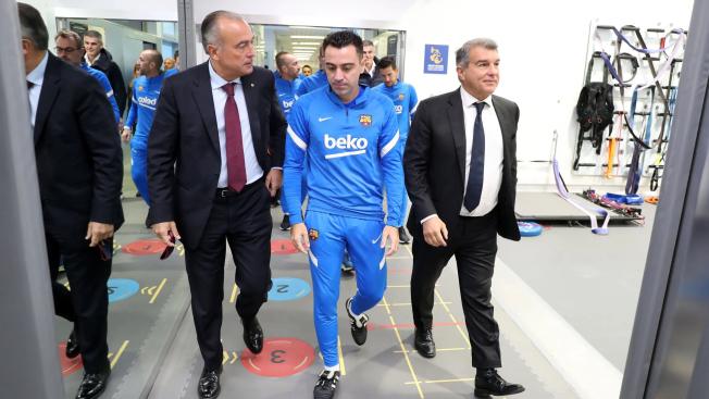 Rafa Yuste, Xavi Hernández y Joan Laporta caminando hacia el vestuario del Barça