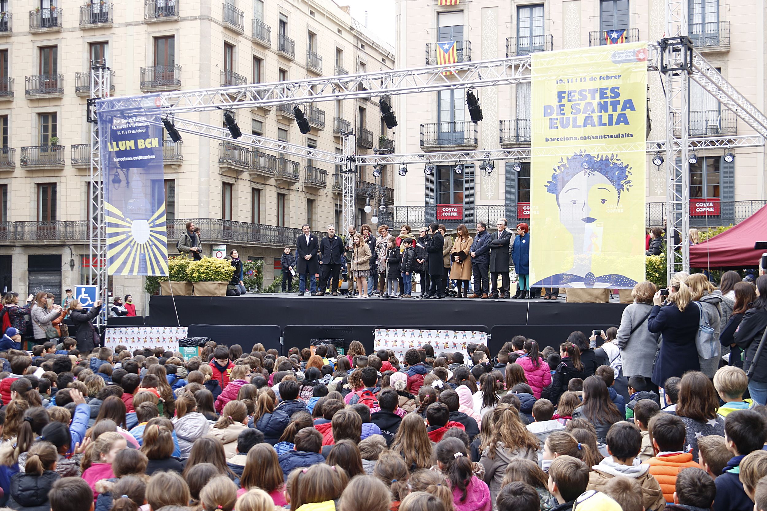 Una monitora enseña a los niños como tienen que recibir a Colau