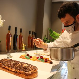 Pla mitjà del pastisser Lluís Costa, acabant de preparar una coca de Sant Joan a la pastisseria Vallflorida de Sant Esteve de Palautordera/ACN