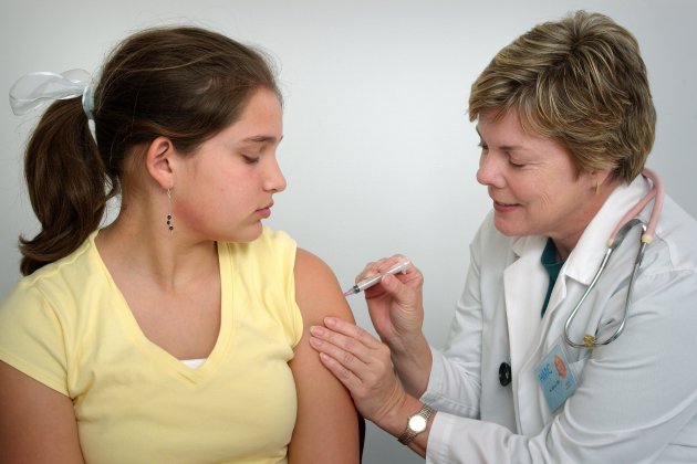 Enfermera vacunando a una niña