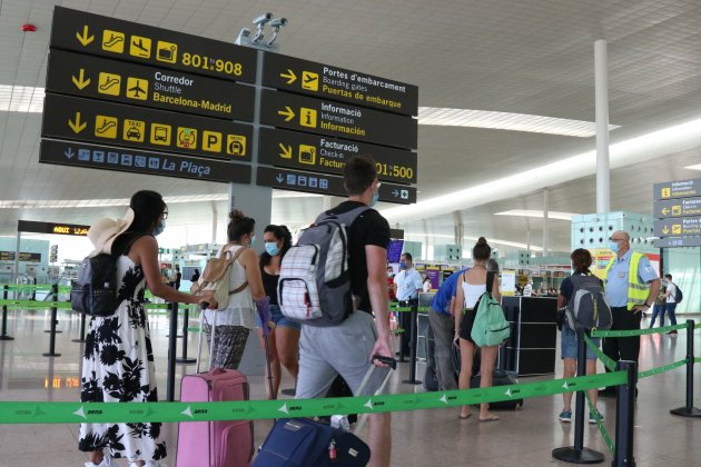 Pla general de passatgers fent cua per accedir a la T1 de l'Aeroport del Prat acn