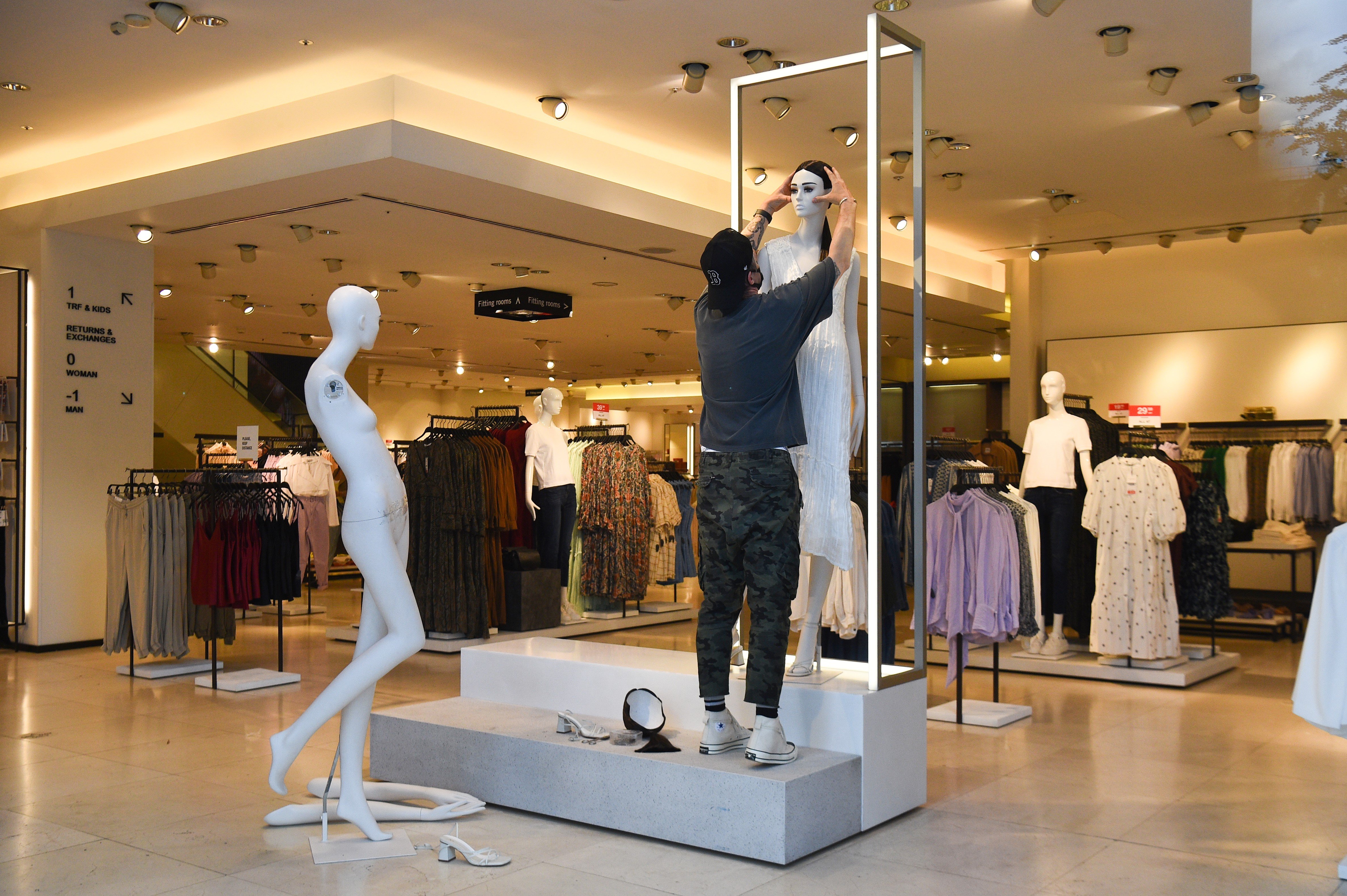 Un treballador vesteix un maniquí a una botiga de Zara. Foto: Europa Press