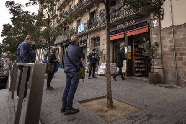 Varias personas esperando delante de un local. Foto: Sergi Alcazar