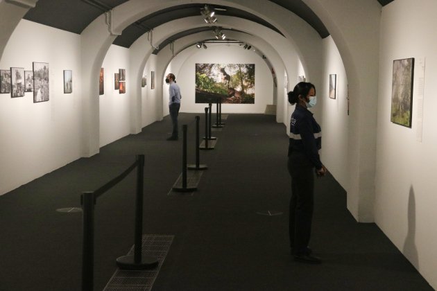 Dos visitants en una sala de l'exposició del World Press Photo 2020 al CCCB ACN