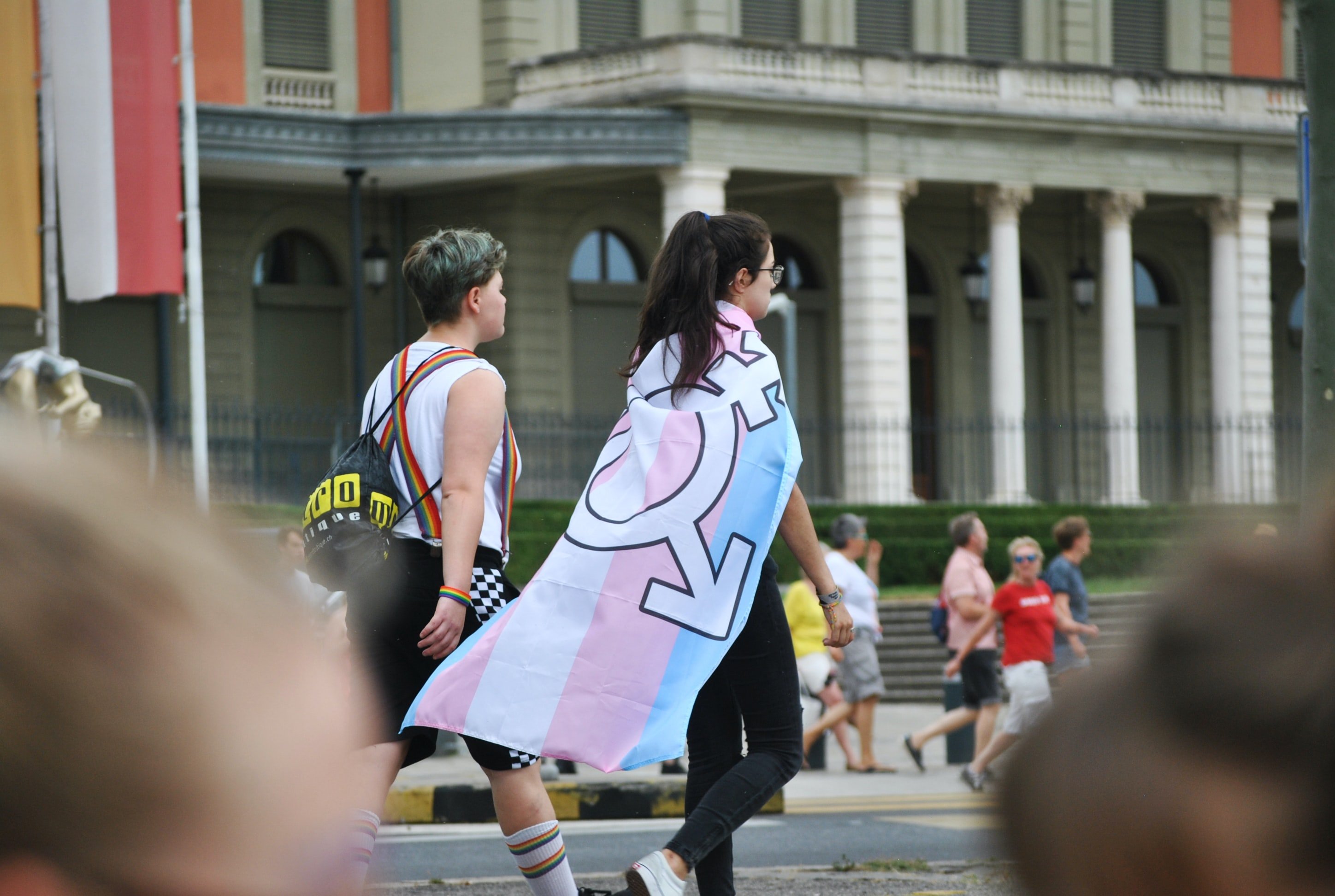 Una chica anda|camina con la bandera trans / Unsplash