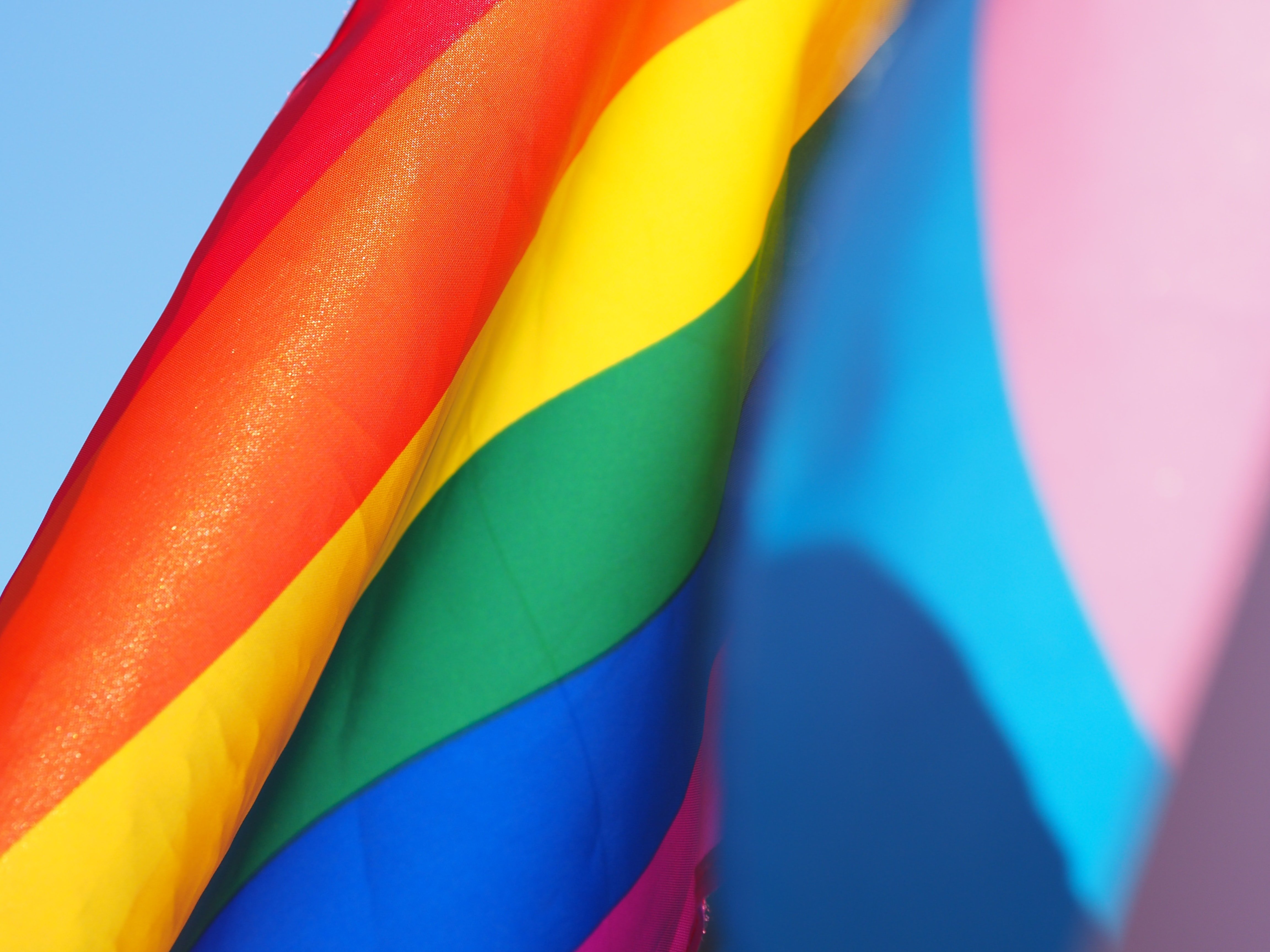 Una bandera LGTBI y otra Trans juntas / Unsplash
