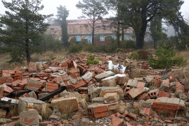 Piles de runes amuntegades a l'antic campament militar de Los Castillejos, amb l'antiga sala d'actes al fons, un edificis més singulars que encara es manté dret ACN