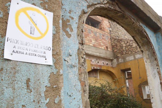 Pla tancat d'un cartell advertint de la prohibició de pas en un vell i degradat edifici de l'antic campament militar de Los Castillejos ACN