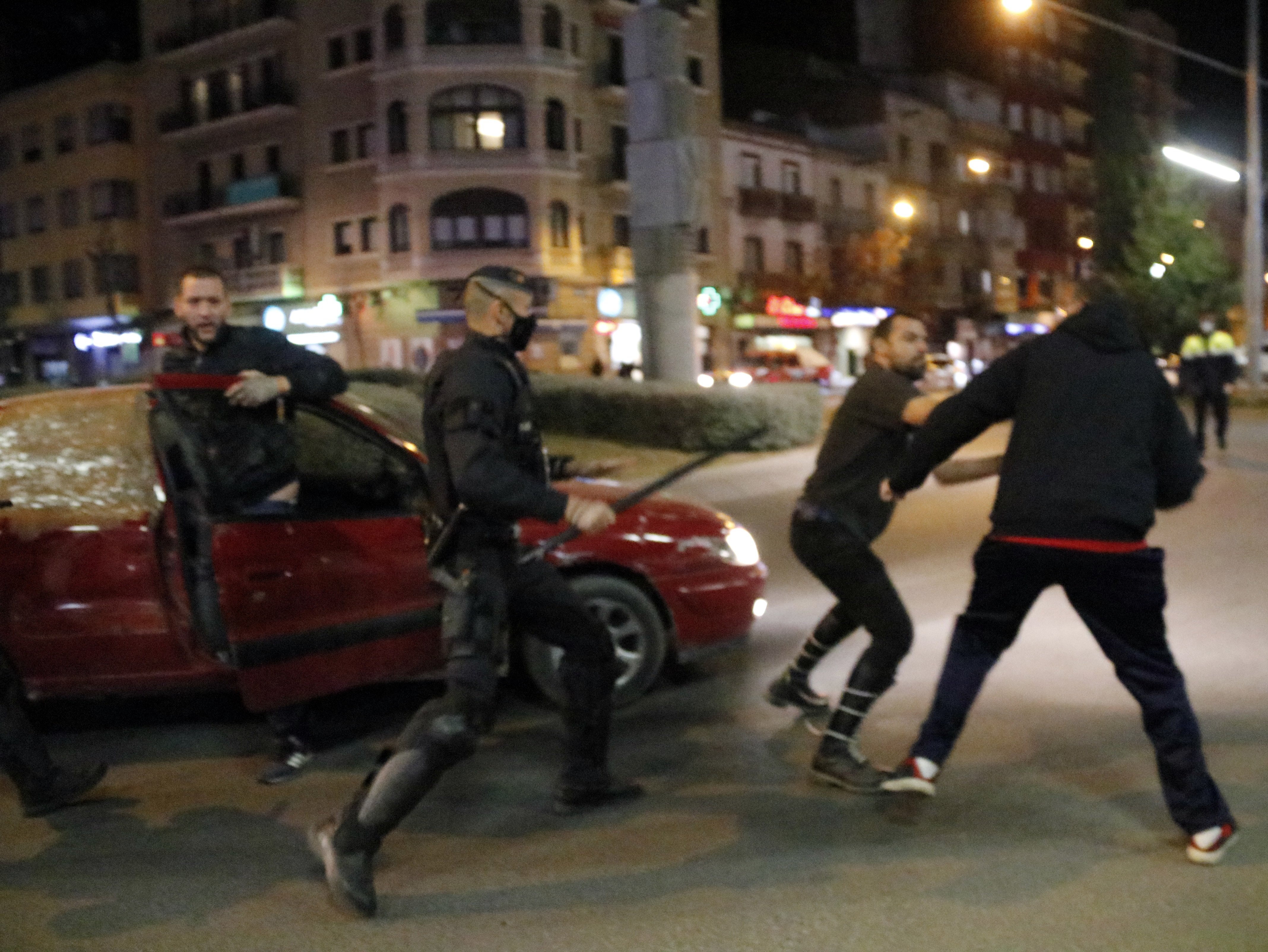 dos hombres, uno de ellos vestido con simbología nazi, en la plaza Ricard Viñes de Lleida mientras agentes de los Mossos d'Esquadra / ACN