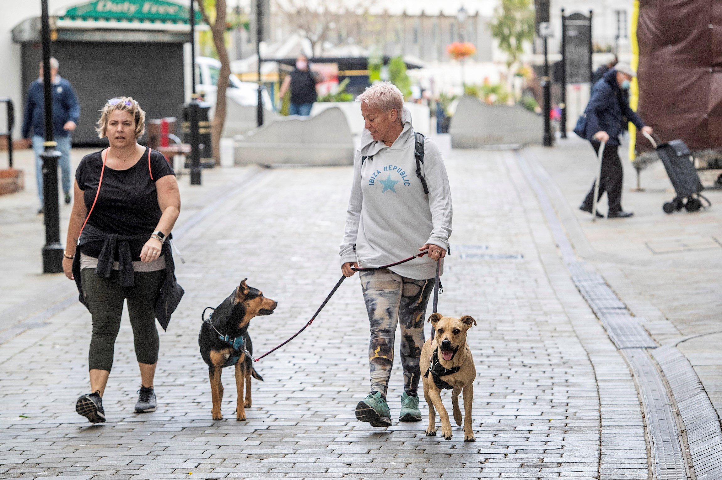 Dos mujeres pasean perros sin mascarilla miedo laso callas de Gibraltar / EFE