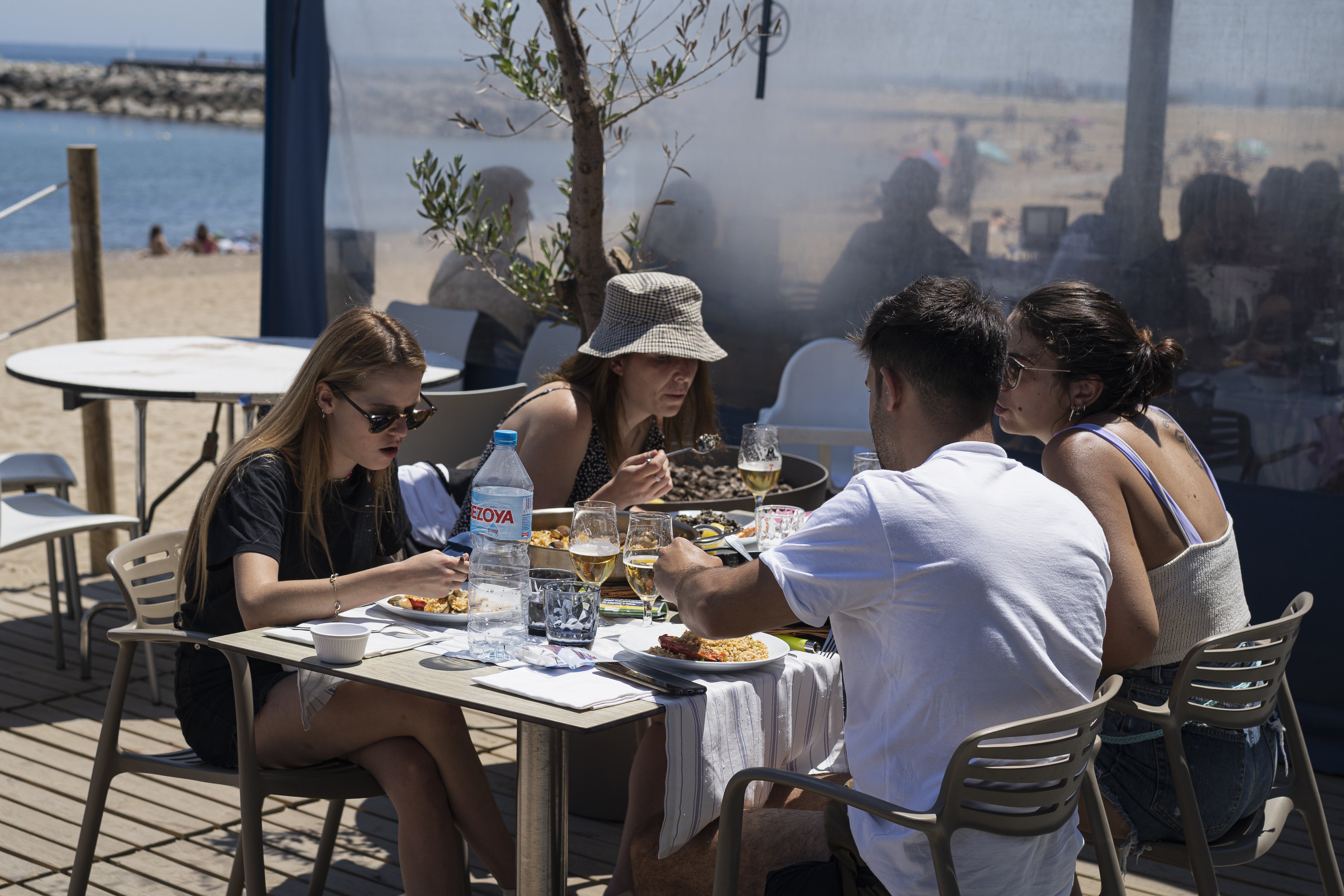 Turistas comiendo en un restaurante de la playa