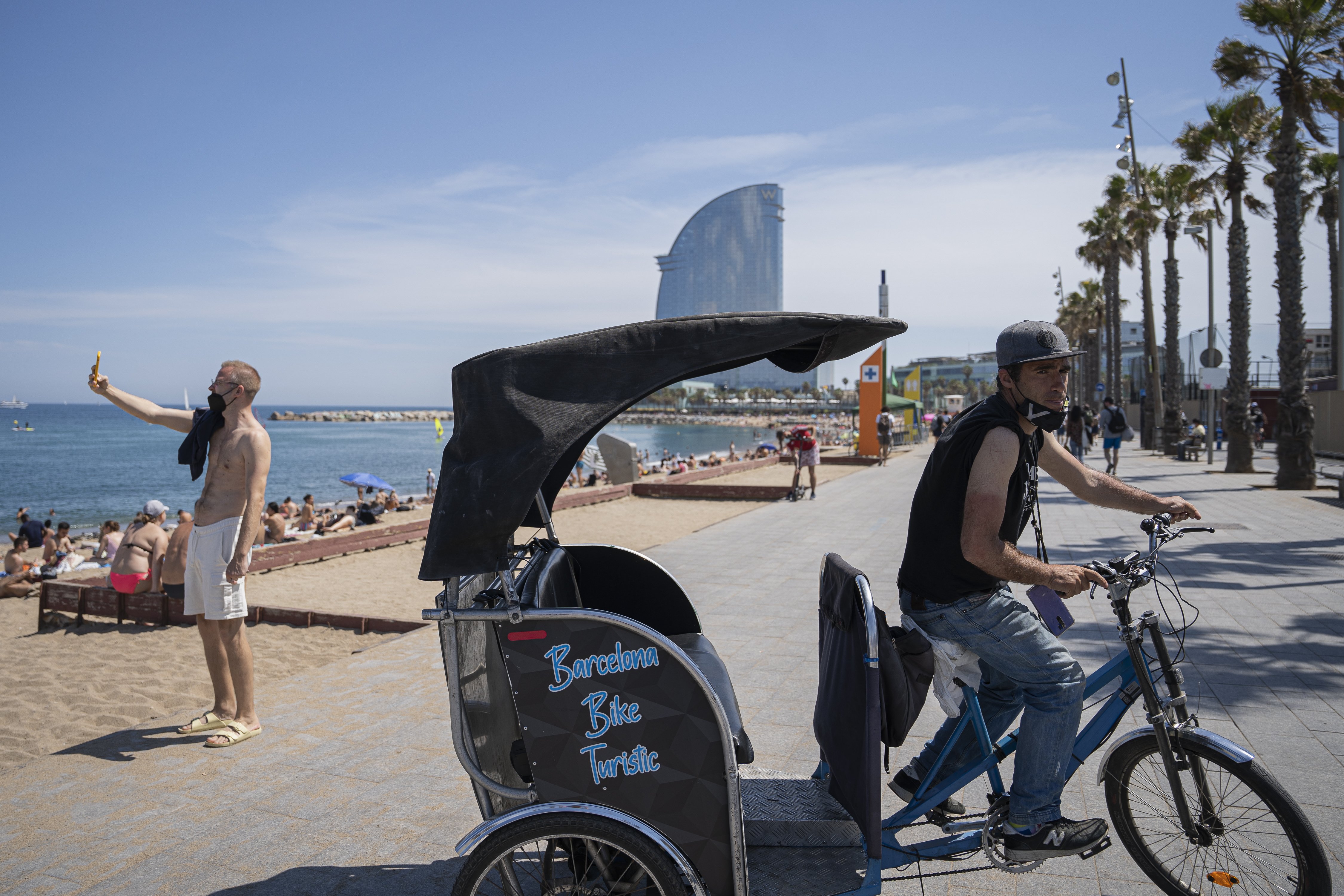 Un trabajador del transporte en bicicleta y un turista haciéndose una foto