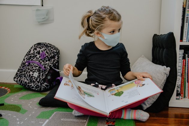 niña leyendo libro mascarilla unsplash