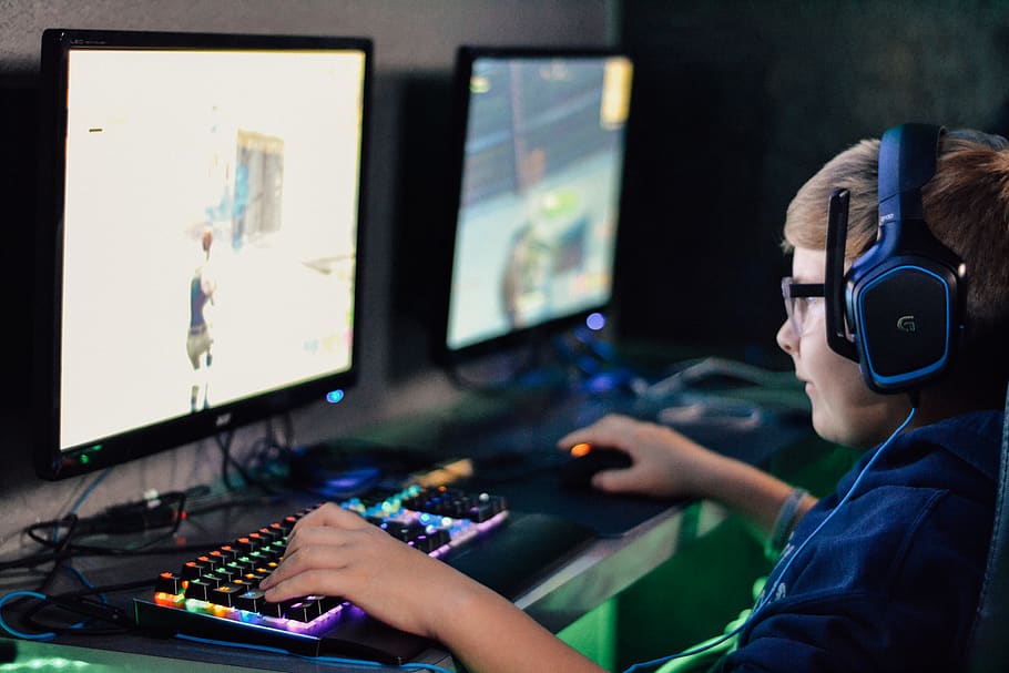 boy wearing headset playing computer game piqsels