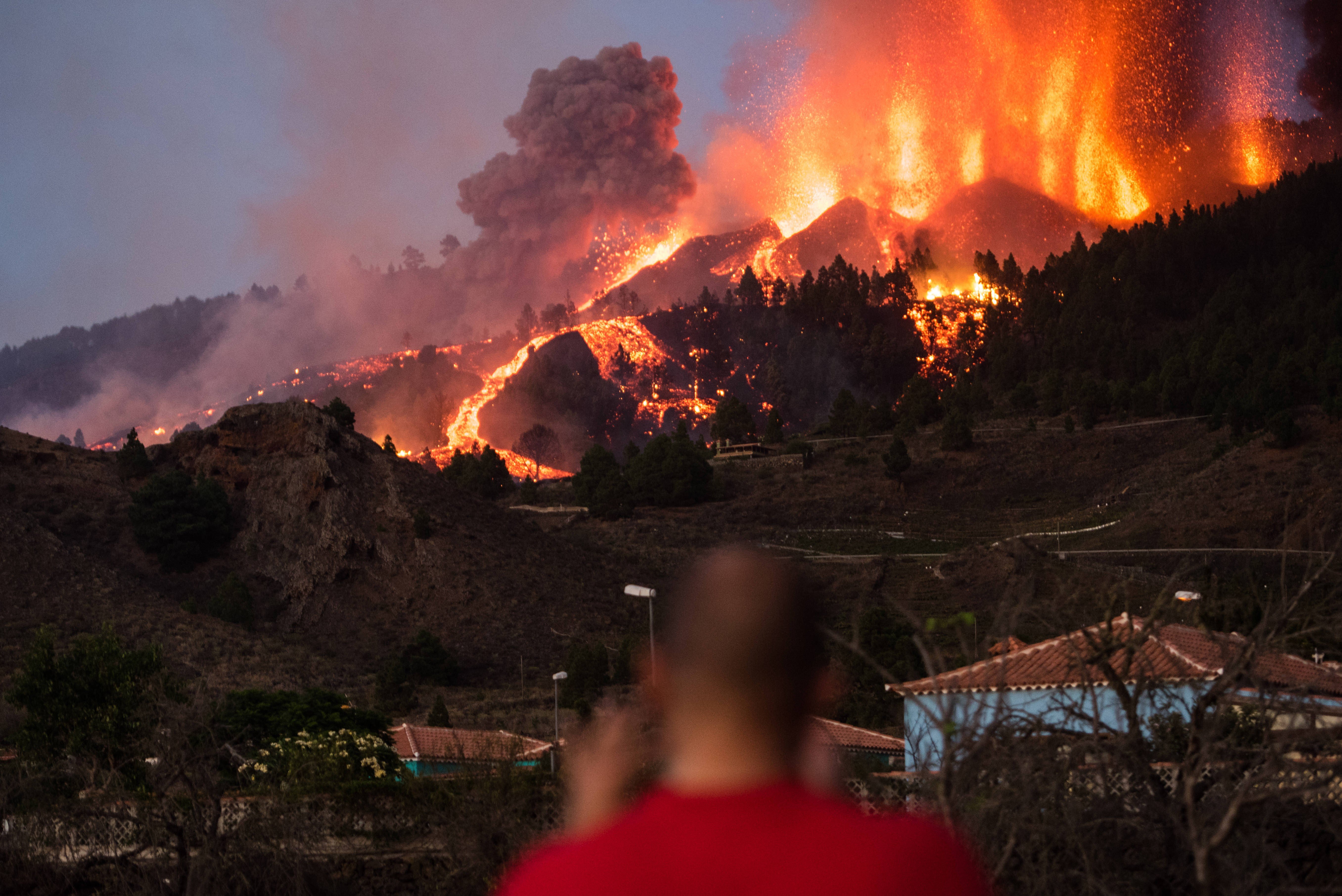 Un chico fotografía la lava y la ceniza del volcán