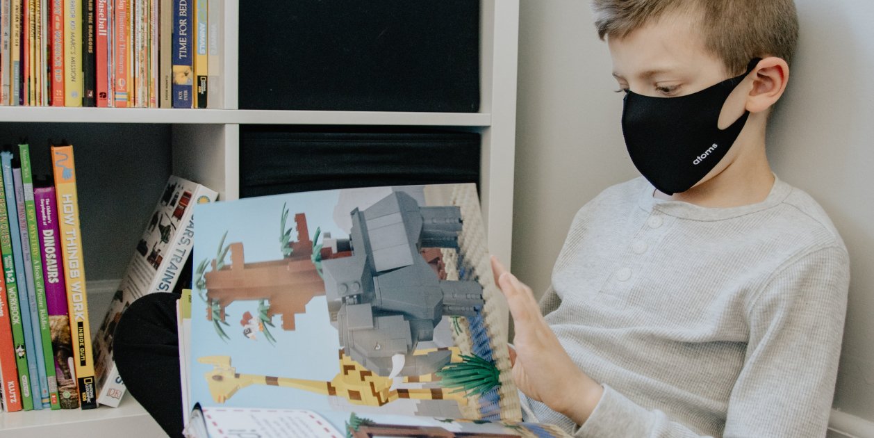 nen llegint llibre mascareta unsplash