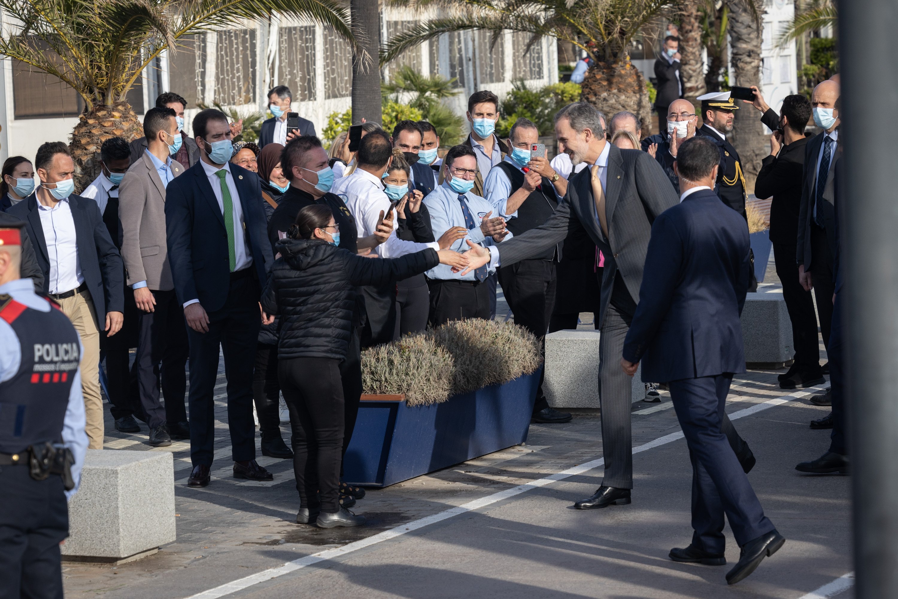 Unas veinte personas aplauden al Rey durante una visita al Port Olímpic