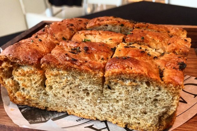 Focaccia con ajos compotados, hierbas frescas y aceite Arbequina