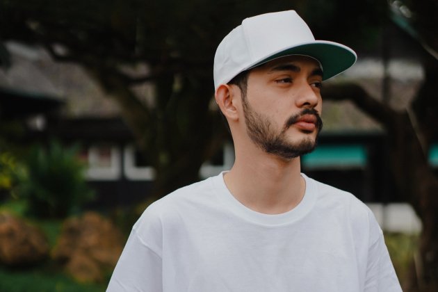 Joven protegiéndose con una gorra Joven protegiéndose con una gorra
