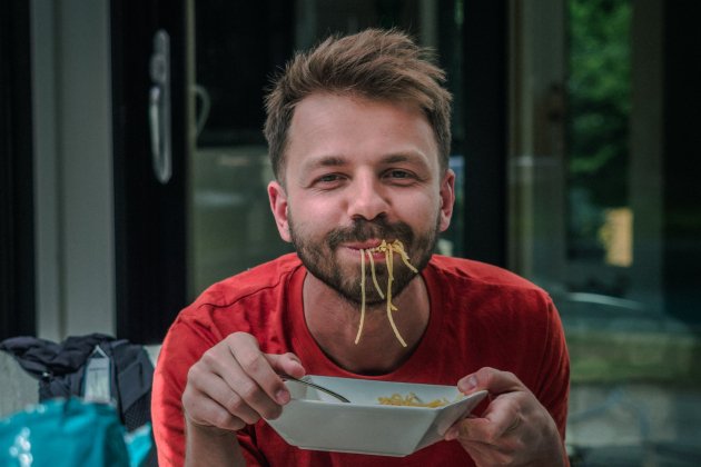 Hombre comiendo entre risas / Unsplash