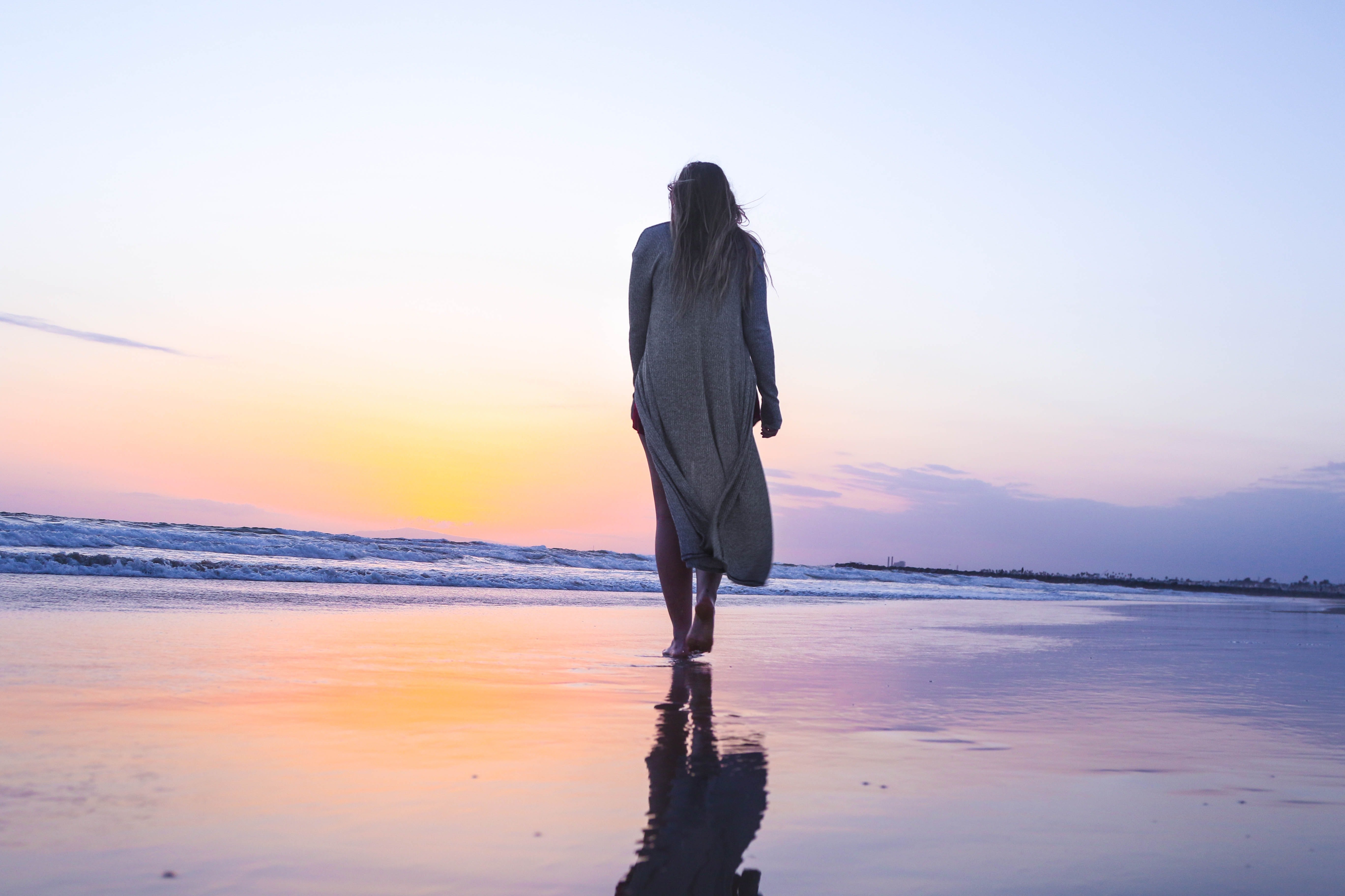 Mujer paseando por la playa / Unsplash