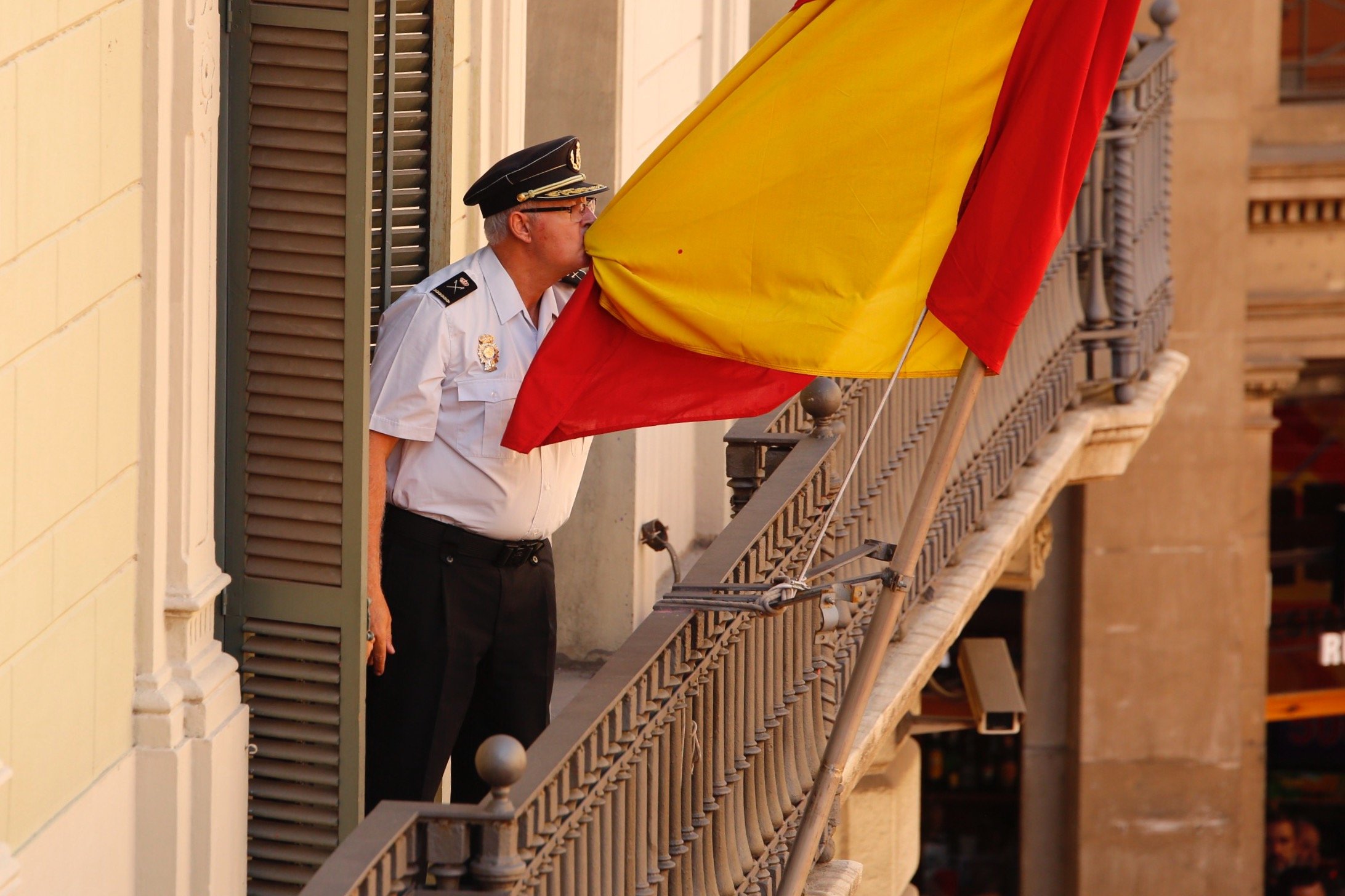 El responsable de la Policia Nacional surt al balcó i besa la bandera davant els manifestants
