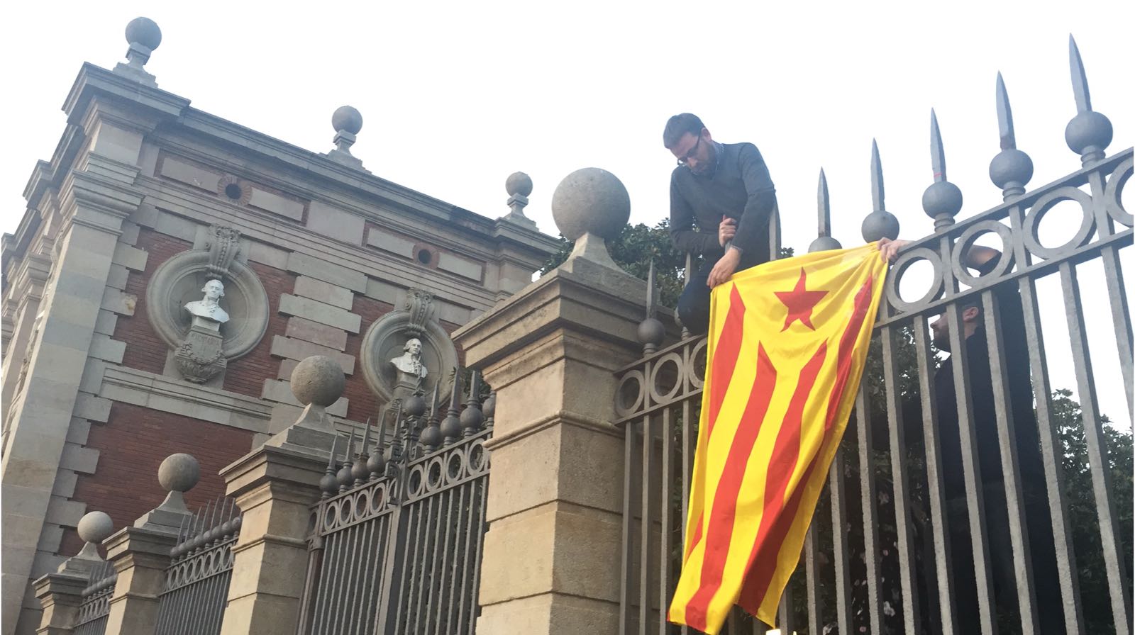 La CUP cuelga una estelada en la reja del Parlament