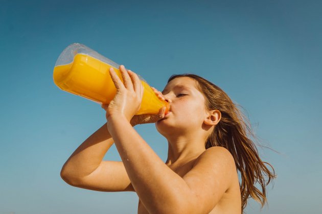 Niña bebiendo zumo de naranja / Unsplash