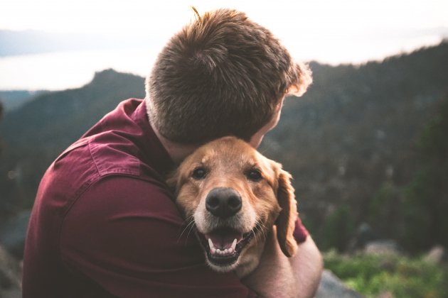 Home abraçant el seu gos / Unsplash