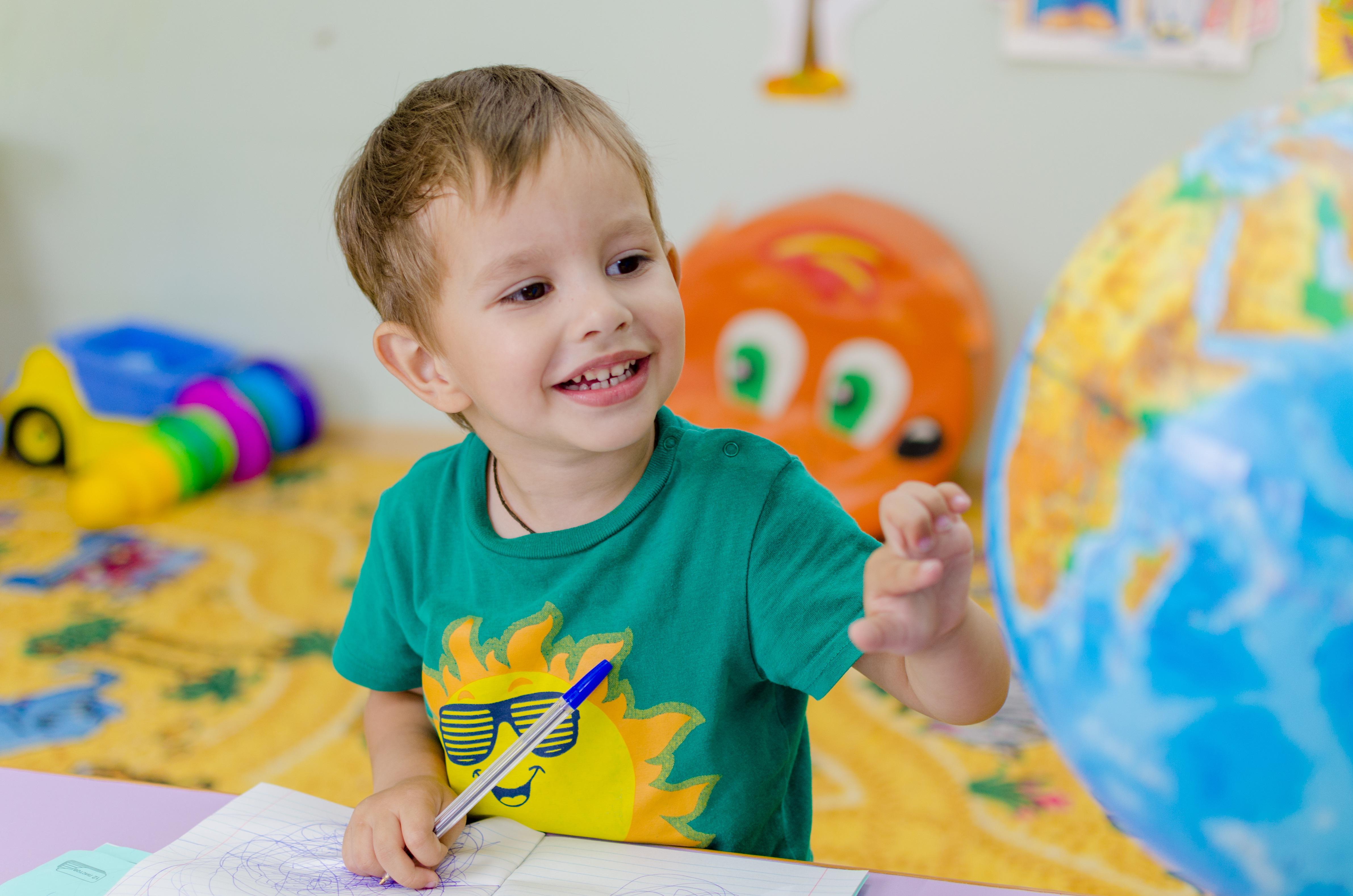 Niño jugando con un globo terráqueo / Pixabay