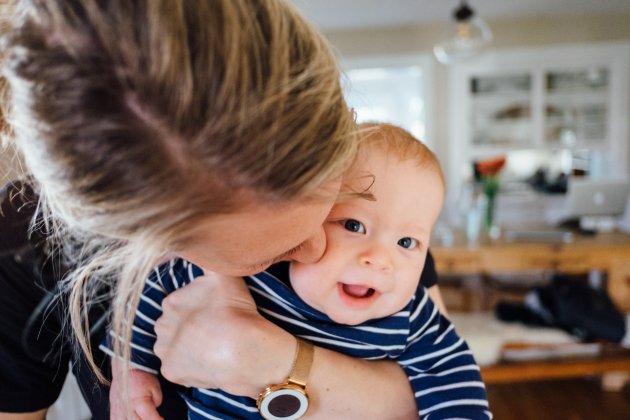 Una madre besa a su bebé / Unsplash