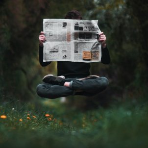 jove llegint diari levitant unsplash