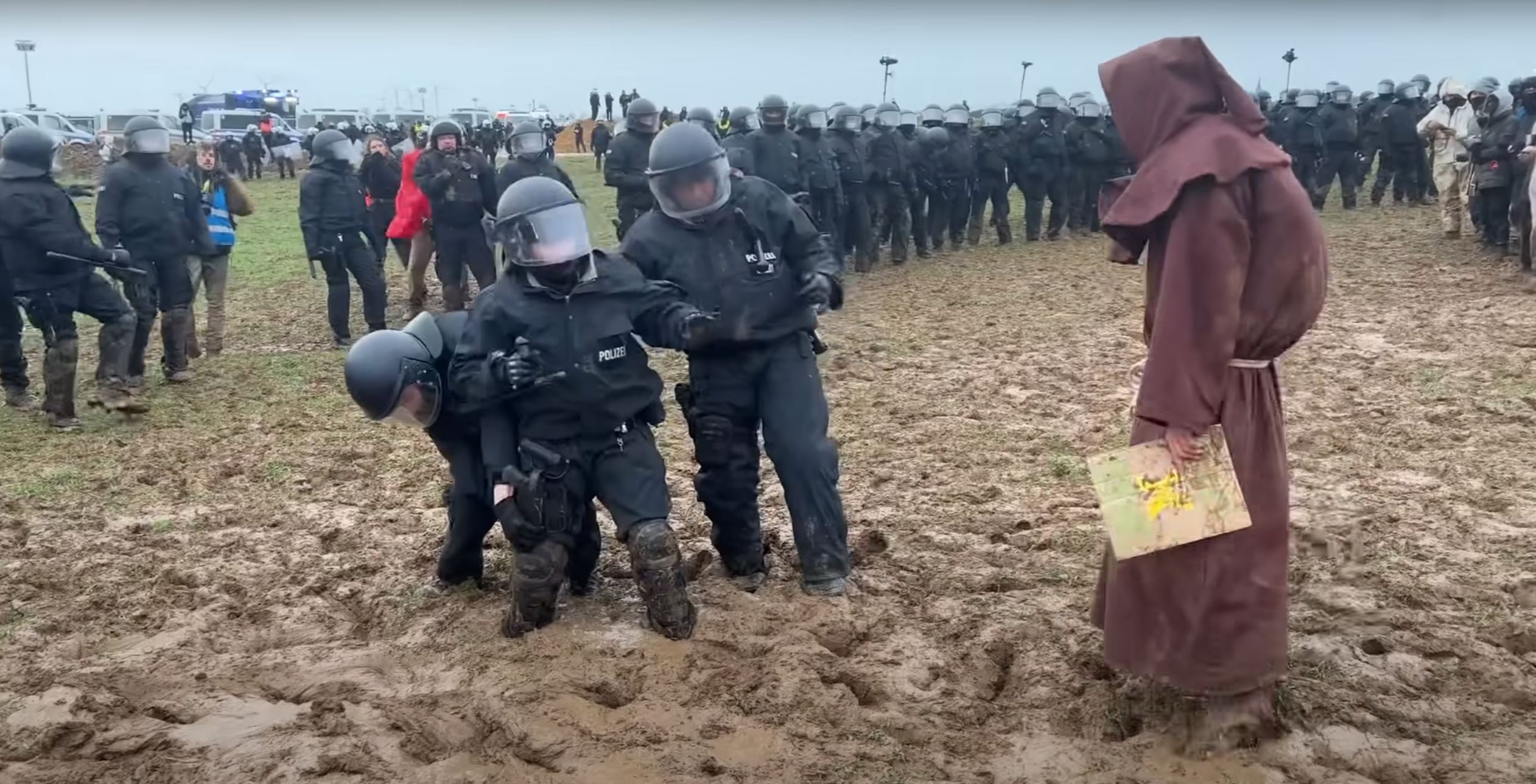 La escena más surrealista de los antidisturbios alemanes: barro, ridículo y un monje misterioso | VÍDEO