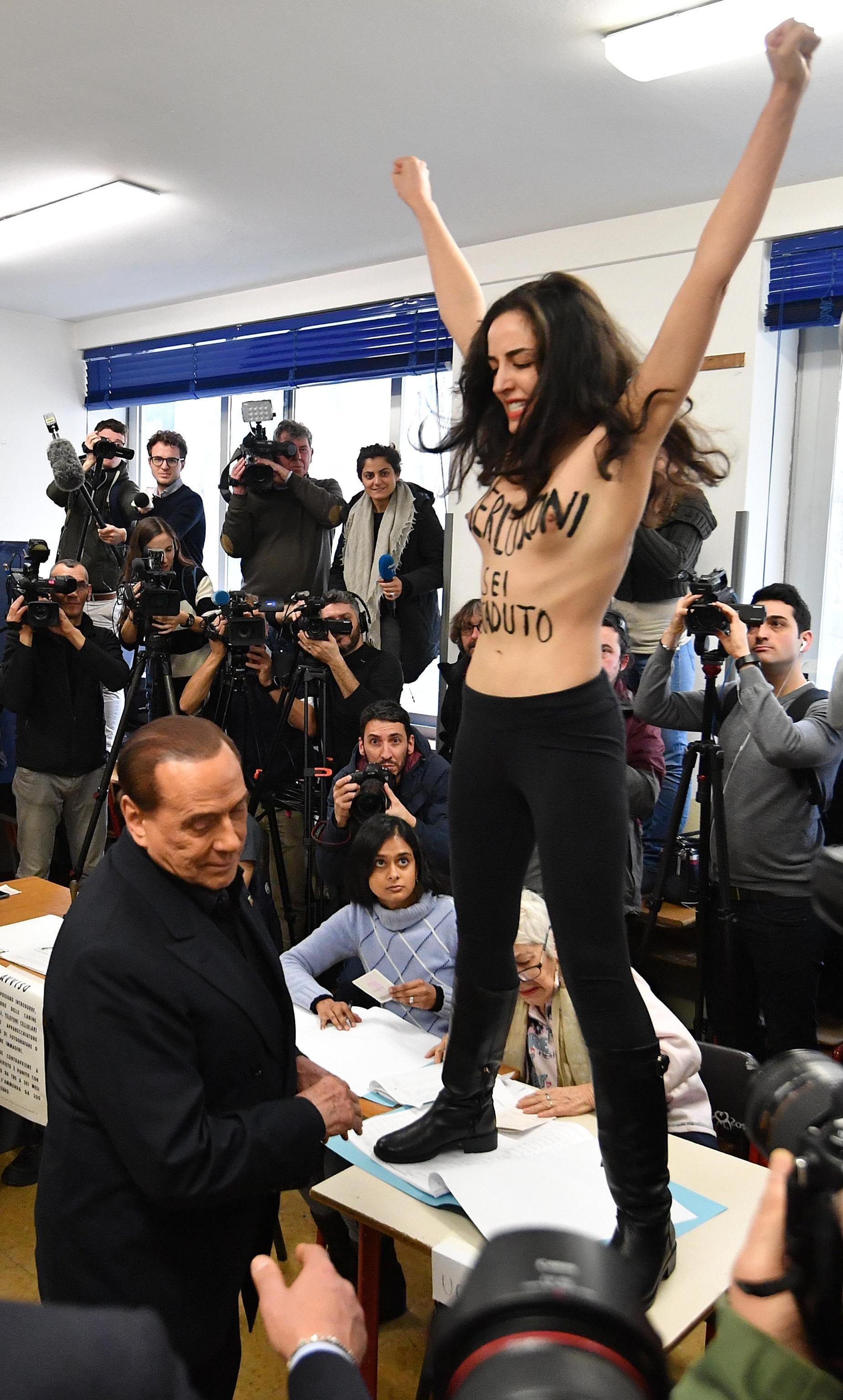 Una activista en topless interrumpe Berlusconi en el momento de votar