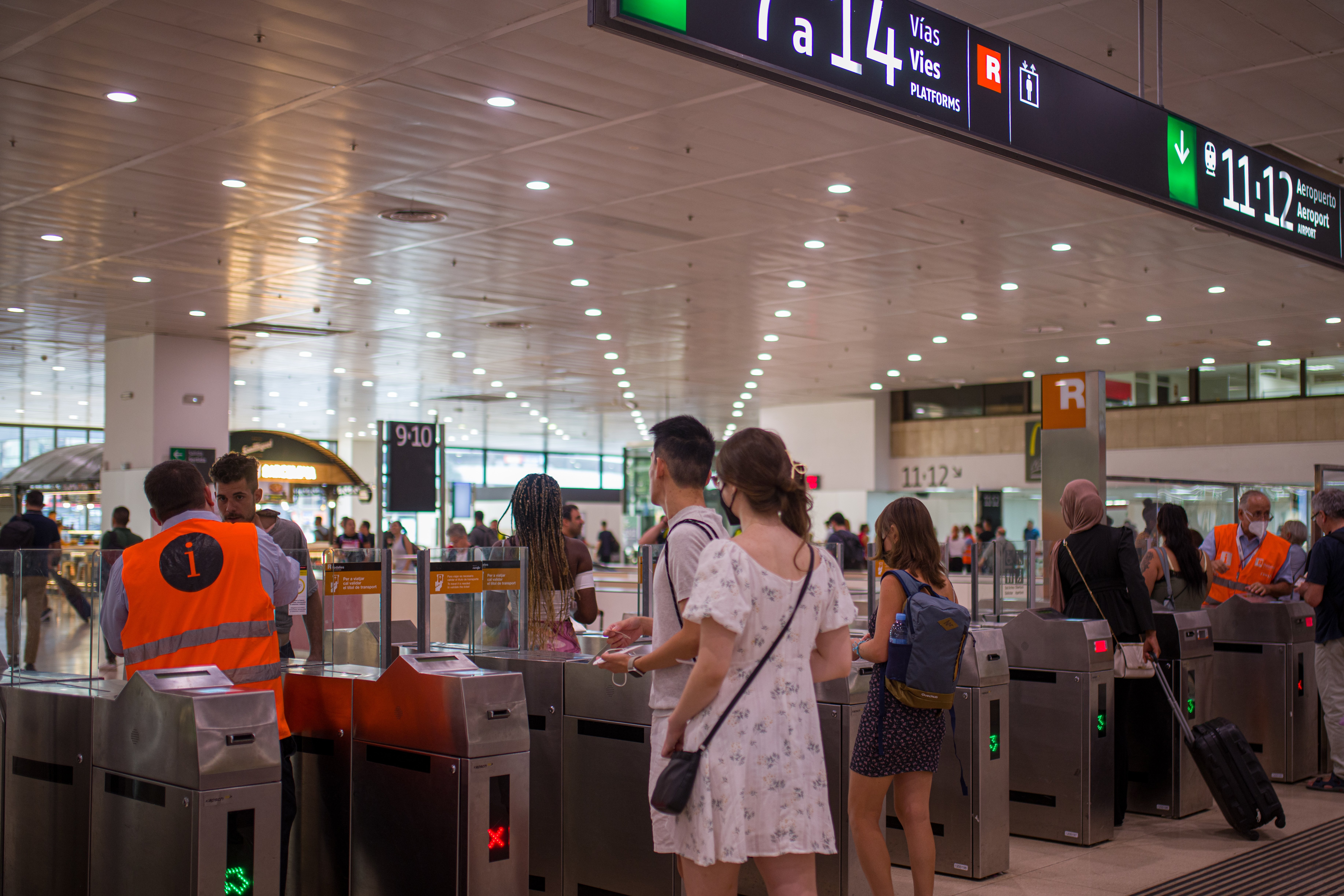 Unos viajeros cruzan los tornos en la Estación de Barcelona-Sants 
