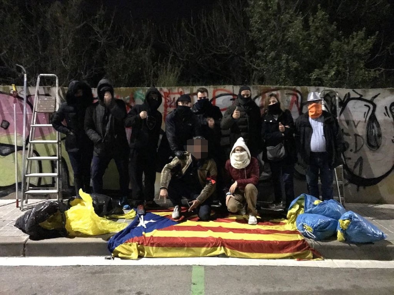 Un grup d'encaputxats "neteja" el Maresme de llaços grocs i estelades