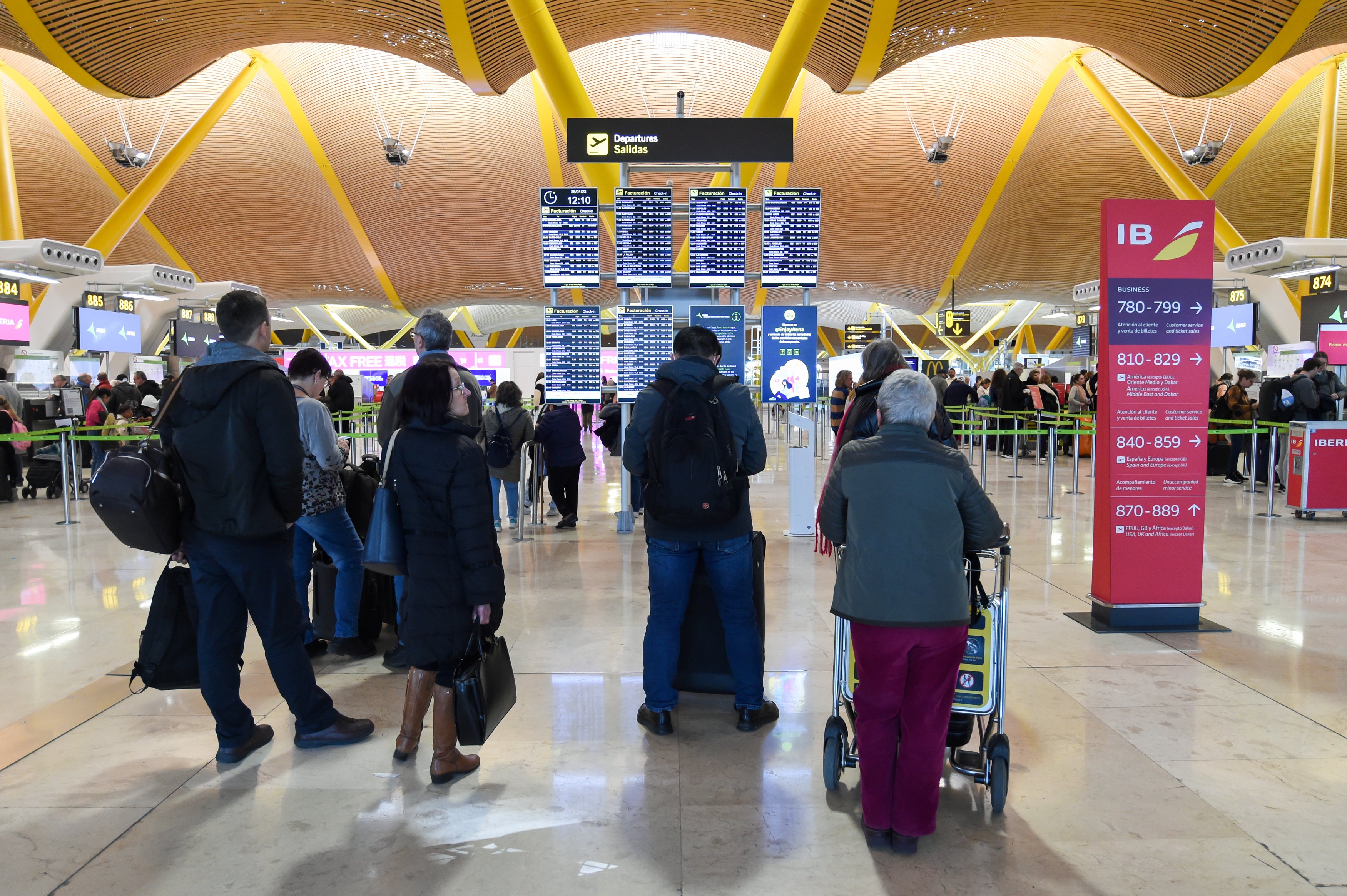 Diverses persones esperen embarcar en la terminal de l'aeroport