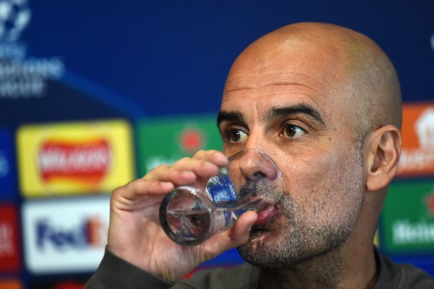 Pep Guardiola bebe agua durante rueda de prensa / Foto: EFE - Peter Powell