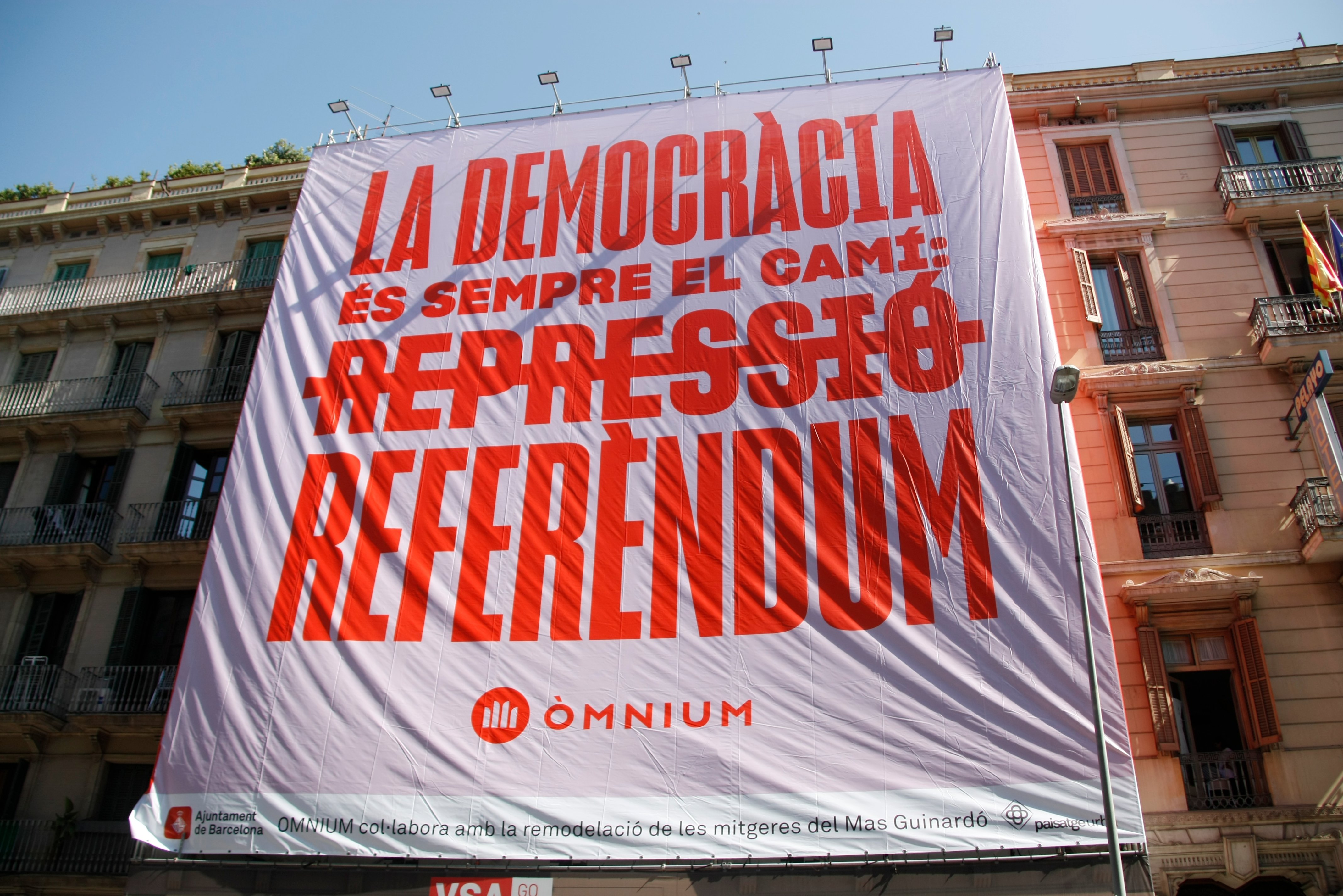 Òmnium Cultural hangs a giant banner calling for a referendum in the centre of Barcelona