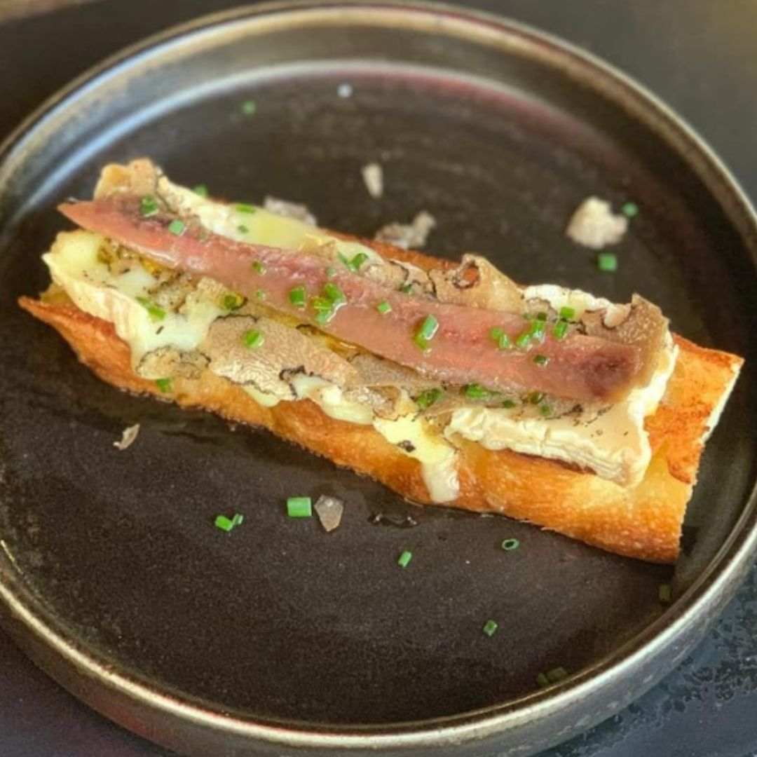 Focaccia tostada, queso brie, trufa de verano y anchoa